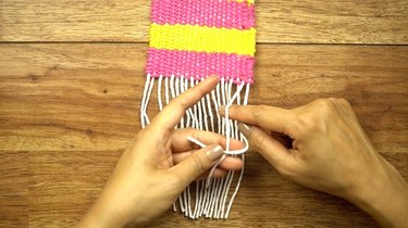 Finished edges of coasters woven on a cardboard loom.