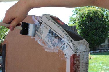 Top and sides of tombstone being covered with papier-mâché