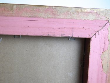 Back of the frame showing the staples holding the cardboard in place.
