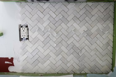 First area of tile placed on wall.