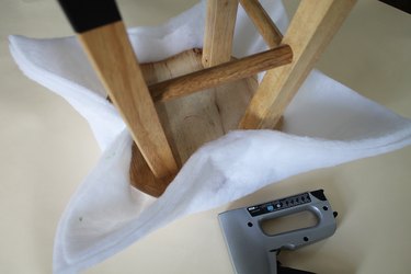 Staple opposite points around the stool.