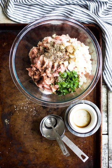 Mixing together turkey burger ingredients.