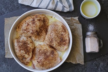 Seasoned chicken thighs in a casserole dish.
