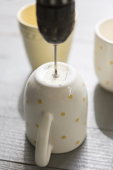 Drilling a hole into the mug.