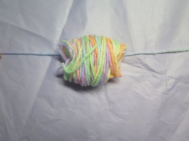 A bundle of yarn placed upon a single strand of yarn