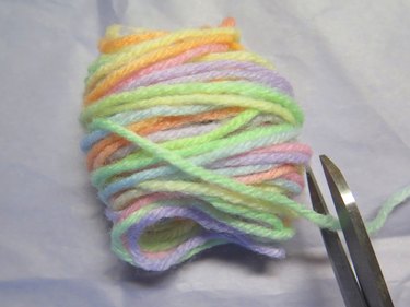 A bundle of yarn that has been wrapped 90 times, ready to snip the end with scissors