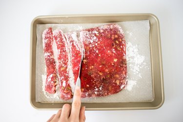 Knife slicing the Turkish delight into strips.