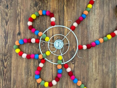 attach other end of pom pom strings to embroidery hoop