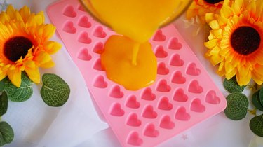pouring fruit mixture into pink heart mold
