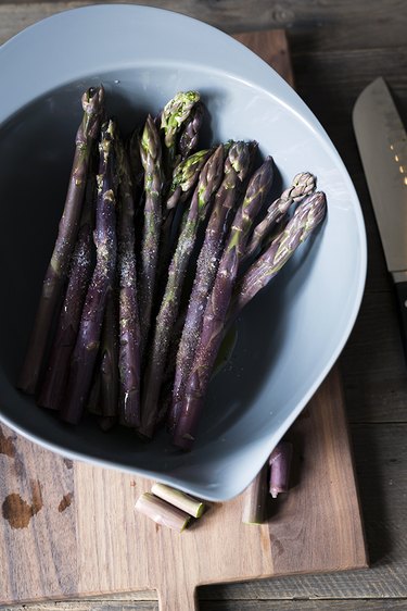 Purple asparagus in blue bowl