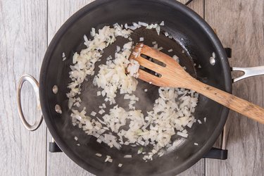 Browning onions in a pan for Cheeseburger Dip