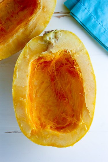 Half of a spaghetti squash with the center scraped of seeds.