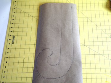 A "J" shape drawn on brown craft paper.