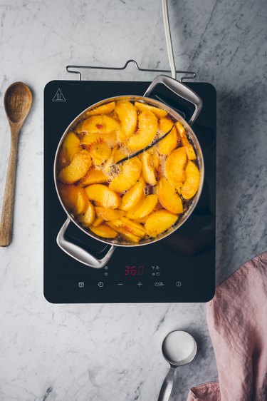 Poached peaches simmering in a pot