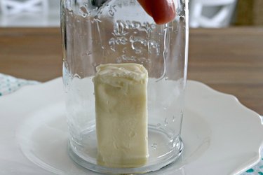 A glass placed over a stick of butter