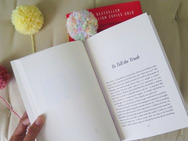 A pompom bookmark within the page of a book