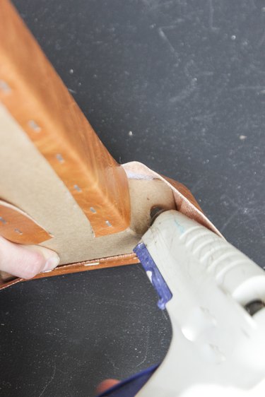 Placing hot glue on the outer serif part of the letter "A", so as to attach the fabric.