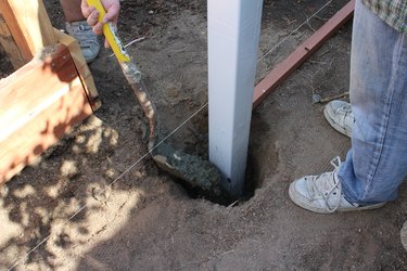 Placing cement around post.