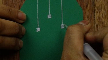 Drawing on cardstock paper to make Christmas ornament gift tags.