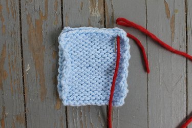 Inserting the needle into the first stitch for whip stitch