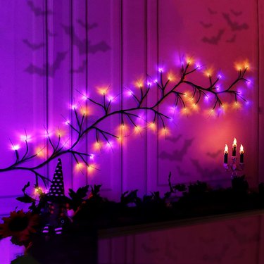 Orange & Purple LED Halloween Willow Branches Arranged Over a Fireplace Mantel.