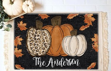 Three decorative pumpkins painted on black coir doormat, personalizes with The Andersons