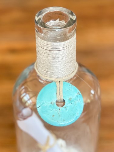 add a turquoise bead or shell around the neck of the bottle