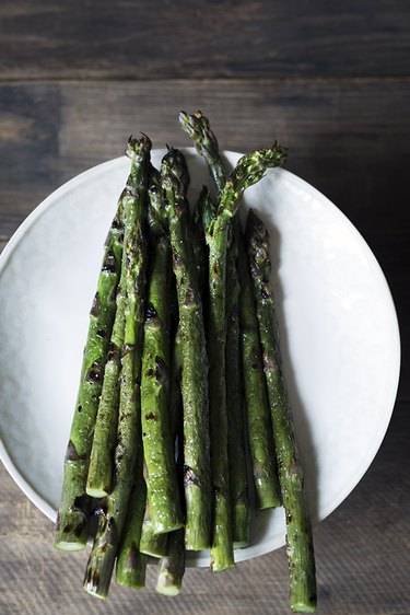 Grilled asparagus on white plate