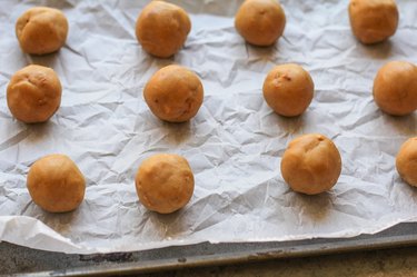 Balls of cookie dough on a baking sheet