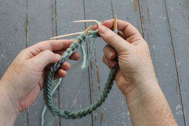Holding the cable needle behind the work