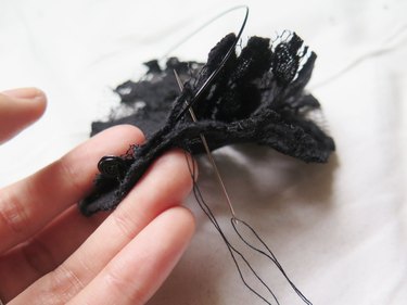 Pulling the thread and needle around again to continue the overcast stitch.