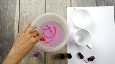 Mixing two nail polish colors for nail polish marbled mugs.