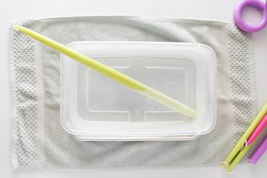 Soaking green taper candle in a bin of hot water