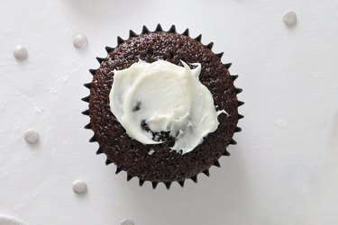 Spreading frosting onto the cupcake