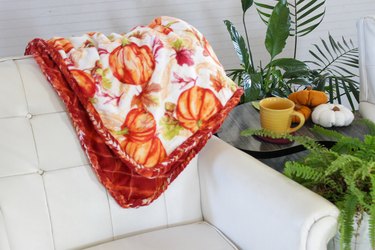 DIY braided fleece blanket draped over a white couch