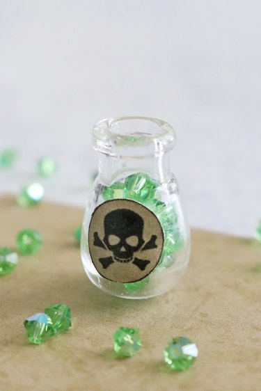 Glass bottle pendant filled with green crystal beads