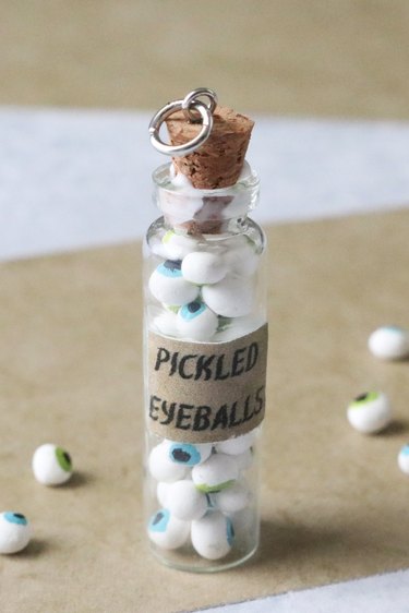 Bottle pendant filled with clay eyeballs and cork glued in place