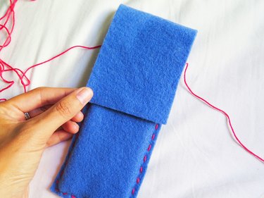 Pulling the flap down over the pencils for the DIY felt pencil case