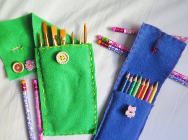 Paint brushes and colored pencils stored in the DIY felt pencil cases in the felt cases.