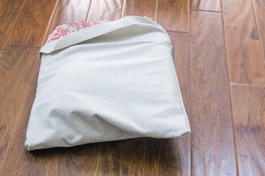 Inserting the patio cushion into the canvas cushion cover
