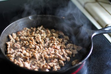 Sausage cooking in a skillet.