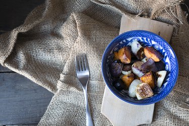 A blue bowl with roasted root vegetables