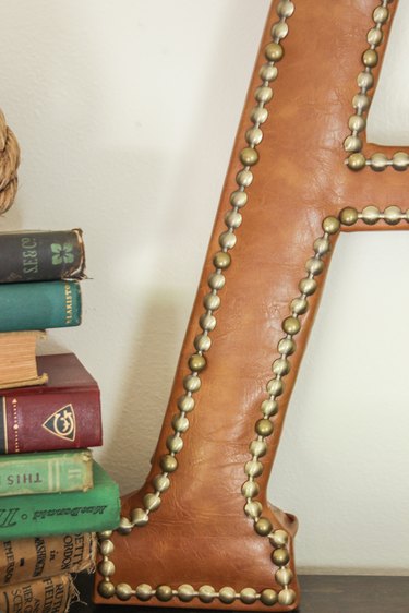 Close shot of finished leather monogram with nailhead trim