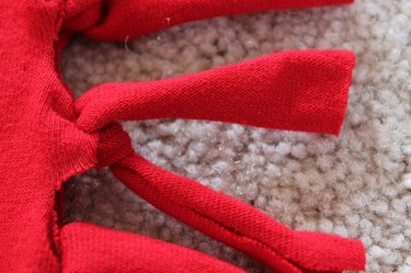 tying the strips into knots along sides of shirt