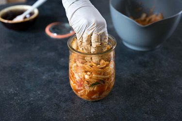 Packing kimchi into a glass jar