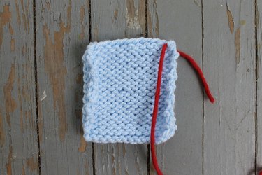 Inserting the yarn at the edge of the knitting for whip stitch