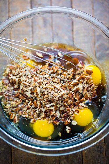 Combine the eggs, pecans, corn syrup, sugars, butter, and salt