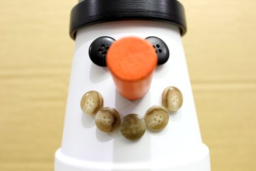 buttons glued to snowman's face to form a smile