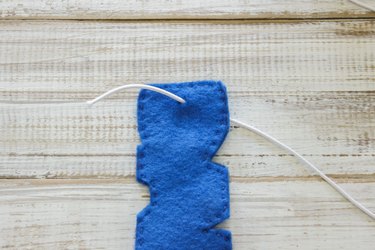 Small hole made in end of one "D" of "DAD" design, with elastic cording strung through.