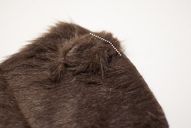 Sew the pony tail to the hood.
